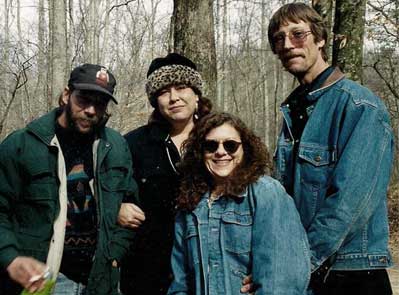 two men and two women in the woods with coats