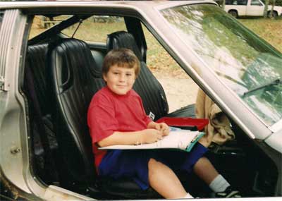 Adrian does homework in a car