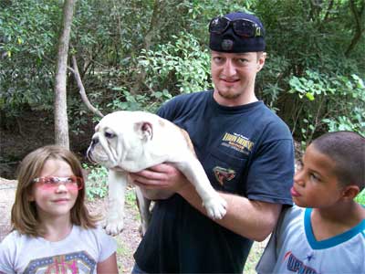 man, a bull dog, and two kids