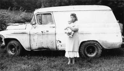 Deborah and baby beside panel wagon