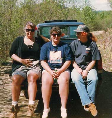 women ride in the back of a truck