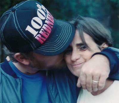 woman getting kissed by man in hat