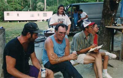 People sitting on a bench watching horseshoe game